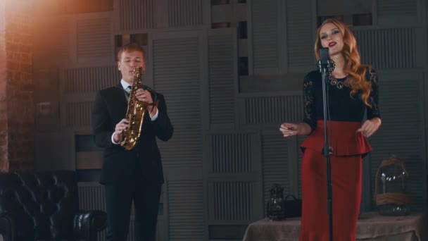 Le duo de jazz se produit sur scène. Saxophoniste en costume. Chanteuse dans un style rétro . — Video