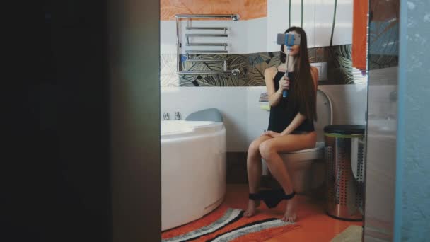 Chica sentada en el baño. Ropa interior negra. Tome selfie en monópodo azul. Posando — Vídeo de stock
