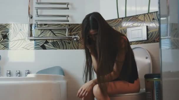 Brunette meisje zittend op toilet emotioneel gesproken op telefoon. Badkamer. Glimlach — Stockvideo