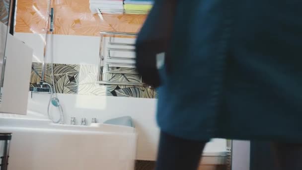 Young girl in blue towel walk into bathroom opening water faucet. Taking bath — Stock video