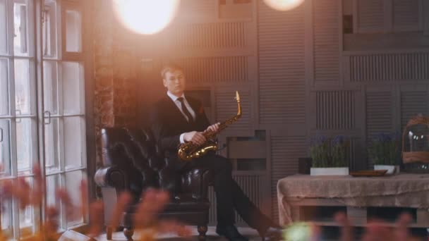 Saxofonista, sedí v křesle na jevišti. Jazzový zpěvák vystoupí na mikrofon. — Stock video