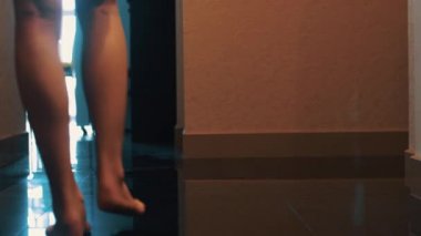 Kadın görünümünü zarif banyo daire içine yürümek. Seksi bacaklar. Kat.