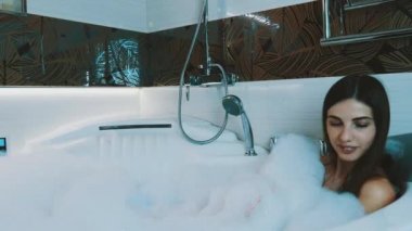Mutlu genç kız alma banyo banyo köpük dolu. Küvet. Hijyen.