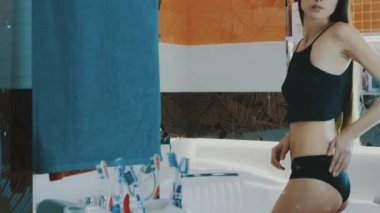 Siyah en iyi kontrol uyluk ve ganimet banyoda ayna önünde ince kız.