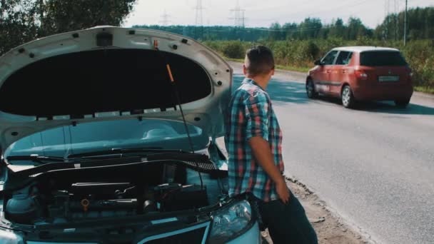 Boy stay at broken car at road. Hitchhiking. Waiting for help. Thumb up. Summer — Stock Video
