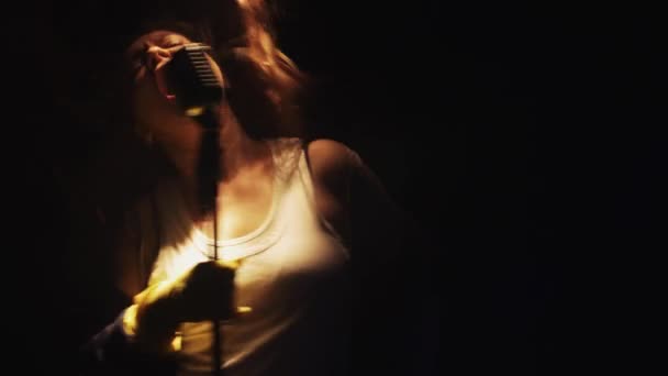 Скраб-жінка в рукавичках співає в старовинному мікрофоні на сцені порожнього клубу. Втікай — стокове відео