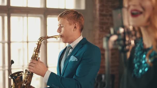 Jazzsångerska i glödande halsband utför på scenen med saxofonist. Sångare. — Stockvideo