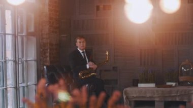 Sahnede caz düet. Saksafoncu sandalyede oturur. Mikrofonda vokalist. Stil