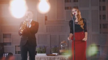 Sahnede caz düet. Saksafoncu. Çekici vokalist şarkı ve parmaklar tıklayın.