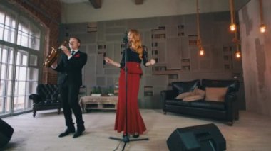 Caz düet Sahne Alanı'nda gerçekleştirin. Saksofoncu ve erkek vokalist. Retro tarzı elbise
