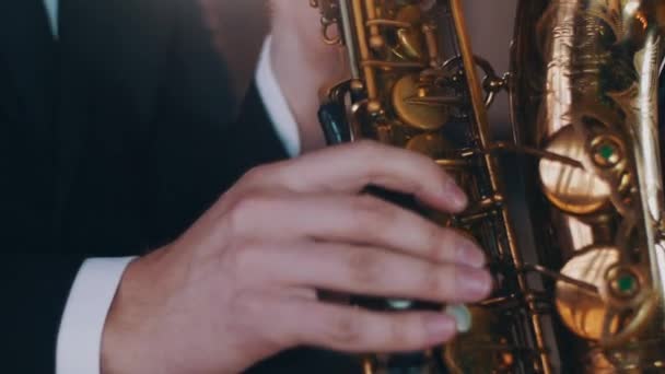 Saxofonist in diner jacket uitvoeren op het podium. Schijnwerpers. Gouden saxofoon — Stockvideo