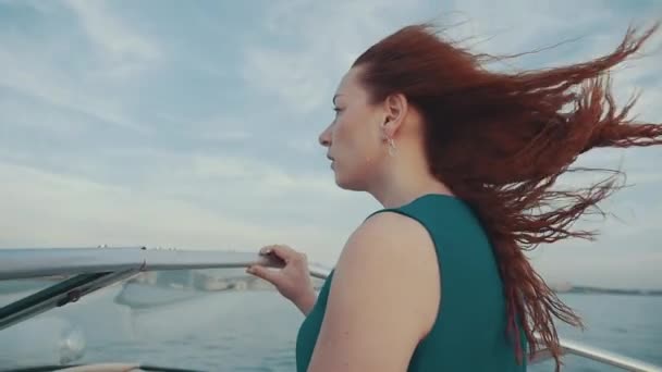 Menina de cabelo vermelho no vestido no barco a motor. Linda noite ventosa de verão. Liberdade — Vídeo de Stock