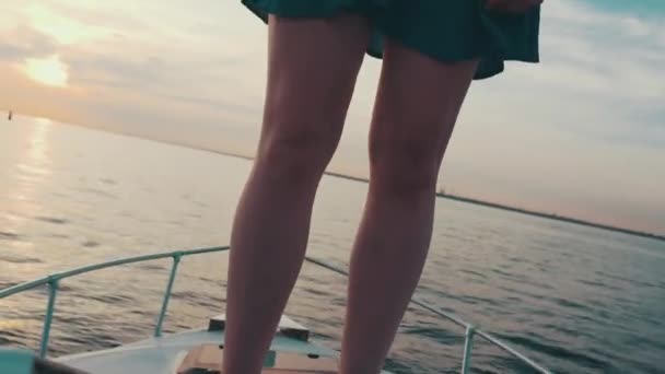 Jeune fille aux cheveux roux debout sur un bateau à moteur. Soirée d'été. Divertissement. Danse — Video