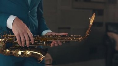 Saksofoncu mavi şık elbiseli aşamada altın saksafon caz oynamak. Müzik