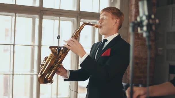 Saxofonista con chaqueta de cena actuando en el escenario. Artista de jazz. Micrófono . — Vídeos de Stock