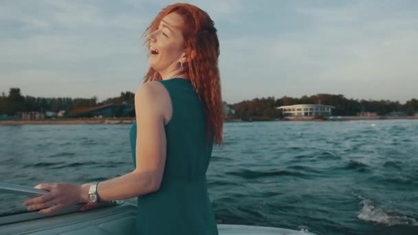 Happy red hair girl in turquoise dress dance on motor boat. Shake hair. Laugh — Stock Video