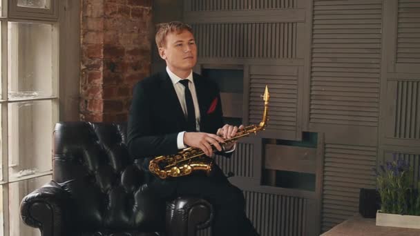 Saxofonista em jaqueta levantar-se no palco com saxofone dourado. Jazz. . — Vídeo de Stock