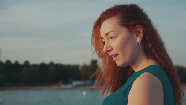 Happy red hair girl in turquoise dress on motor boat. Looking sunset. Smile. — Stock Video
