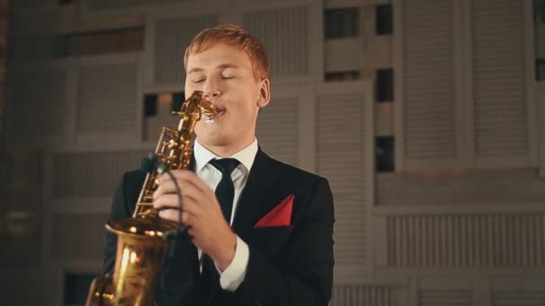 Saxofonista en chaqueta de cena de pie en el escenario con saxofón dorado. Músico de jazz — Vídeos de Stock