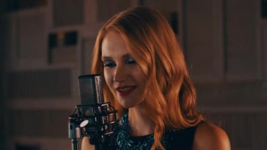 Şarkıcı parlak makyaj ile gerçekleştirmek sahnede konser mikrofon. Caz. Retro