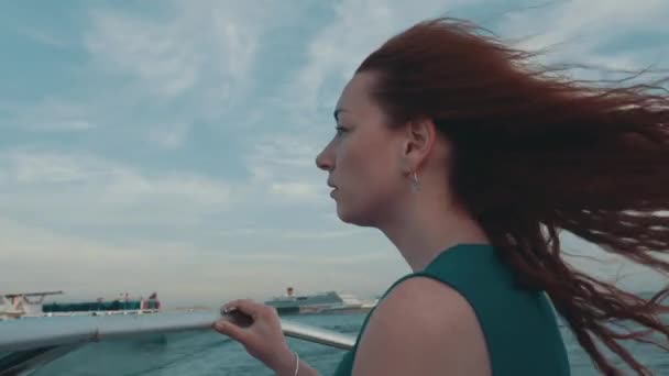 Rote Haare Mädchen in türkisfarbenem Kleid fahren Motorboot. Sommerabend. Wind. Natur — Stockvideo