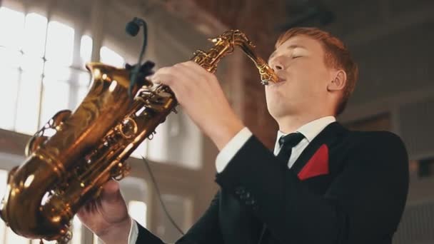 Saxofonist i middag jacka spela jazz på gyllene saxofon på scenen. Musik. — Stockvideo