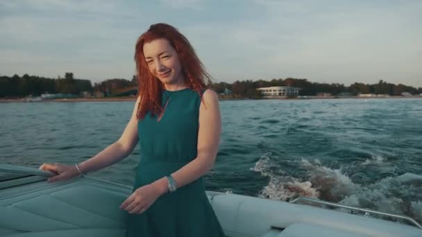 Gott rött hår flicka i turkos klänning på motorbåt. Tryck på hår. Kul. Leende. — Stockvideo