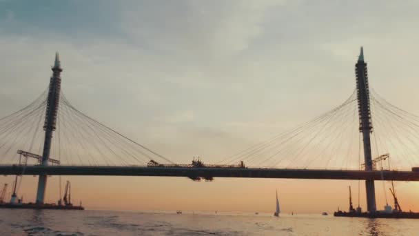 Τεράστια γέφυρα στην πόλη το καλοκαίρι βράδυ. Μαγευτικό ηλιοβασίλεμα. Ποταμός. Φύση. — Αρχείο Βίντεο