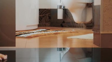 Genç kız yürüyüş için banyo lavabo için geldim. Küçük halı. Çıplak bacaklar. Daire