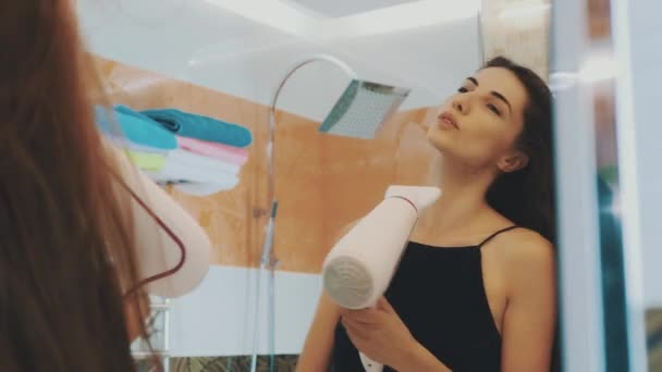 Esmer genç kız banyoda ayna, saç kurutma makinesi ile dans. Saç sallamak — Stok video