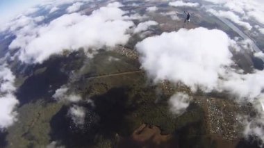 Skydiver kırmızı paraşüt alanı üzerinde gökyüzünde açılır. Manzara. Bulutlar. Yükseklik.