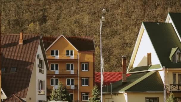 Modern buildings on street at foot of mountains. Evening in city. Architecture. — Stock Video