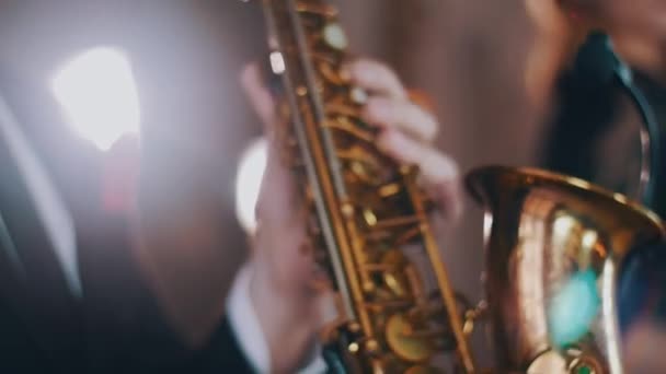 Saxofonist in diner jacket uitvoeren op het podium. Middelpunt van de belangstelling. Gouden saxofoon. Jazz — Stockvideo