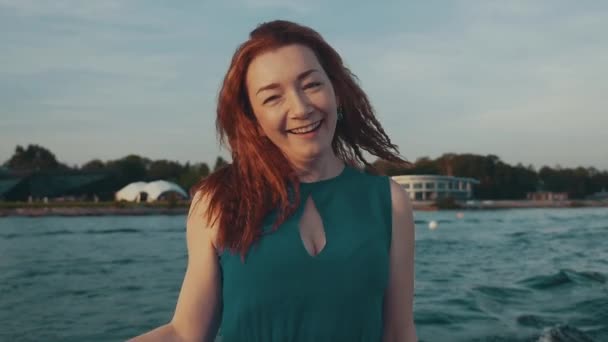 Chica de pelo rojo feliz en baile vestido de turquesa en barco a motor. Hermosa noche — Vídeo de stock