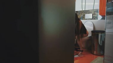 Tuvalette smartphone kullanarak iç çamaşırı oturan genç kız. Banyo.