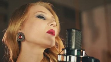 Vokalist parlak makyaj ile gerçekleştirmek mikrofon sahnede. Caz. Küpe