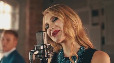 Kırmızı dudaklar ile şarkıcı mikrofon sahnede gerçekleştirin. Retro tarzı. Saksofoncu