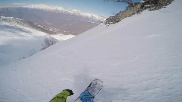 Snowboarder backcountry extreme rijden vanaf bovenkant van besneeuwde berg. Zonnige dag. — Stockvideo