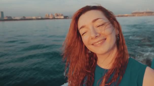 Red hair girl in turquoise dress sail on motor boat. Beautiful sunset. Relax — Stock Video