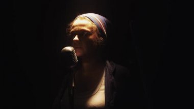 Scrubwoman başlangıç vintage mikrofona club sahnede şarkı. Paspas ile dans