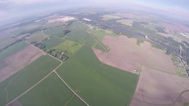 Professionella fallskärmshoppare Fallskärmshoppning i himlen över gröna flatland. Landskap. Vacker natur — Stockvideo