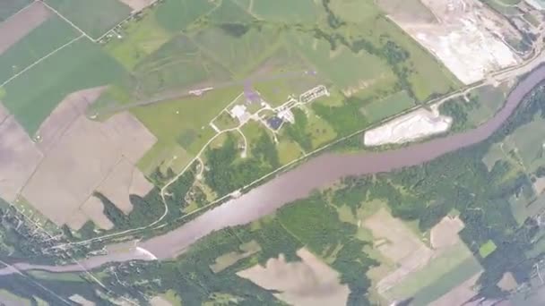 Fallschirmspringer öffnen Fallschirm am Himmel. fliegen über grünes Flachland. Trübung — Stockvideo