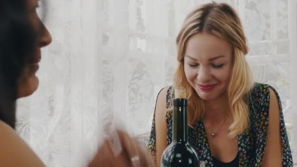 Szczęśliwy dziewczyny na czacie przy stole z butelką wina na tarasie rezydencji wiejskiej. — Wideo stockowe