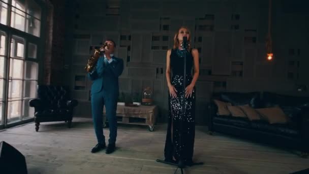 Vocalista de jazz atraente em vestido brilhante no palco com saxofonista. Dança — Vídeo de Stock