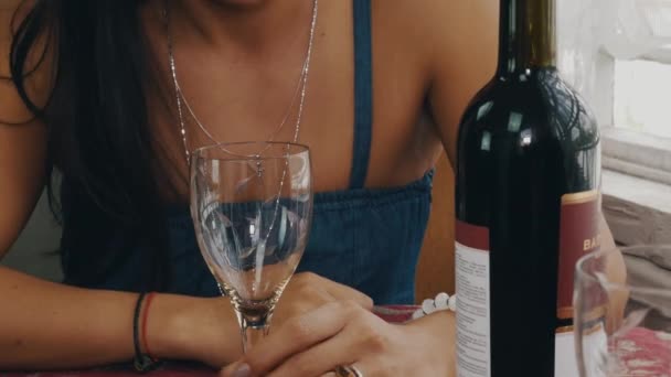 Ragazza che chatta a tavola con bottiglia sulla terrazza della casa di campagna. Vetro vuoto . — Video Stock