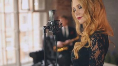 Caz vokalisti saksofoncu ile sahne alanı'nda gerçekleştirin. Retro tarzı. Parlak makyaj