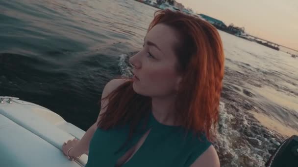 Pretty red hair girl in turquoise dress on motor boat. Summer evening. Nature — Stock Video