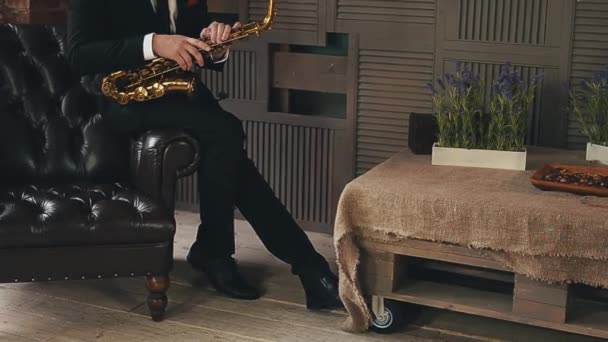 Saxofonista en chaqueta de cena sentarse en la silla con saxofón dorado. Músico de jazz . — Vídeos de Stock