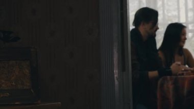 İki kız ve adam masada ülkenin evin terasında alkollü içecekler ile sohbet