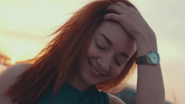 Young girl in turquoise dress touch hair on motor boat. Sunset. Smile in camera — Stock Video